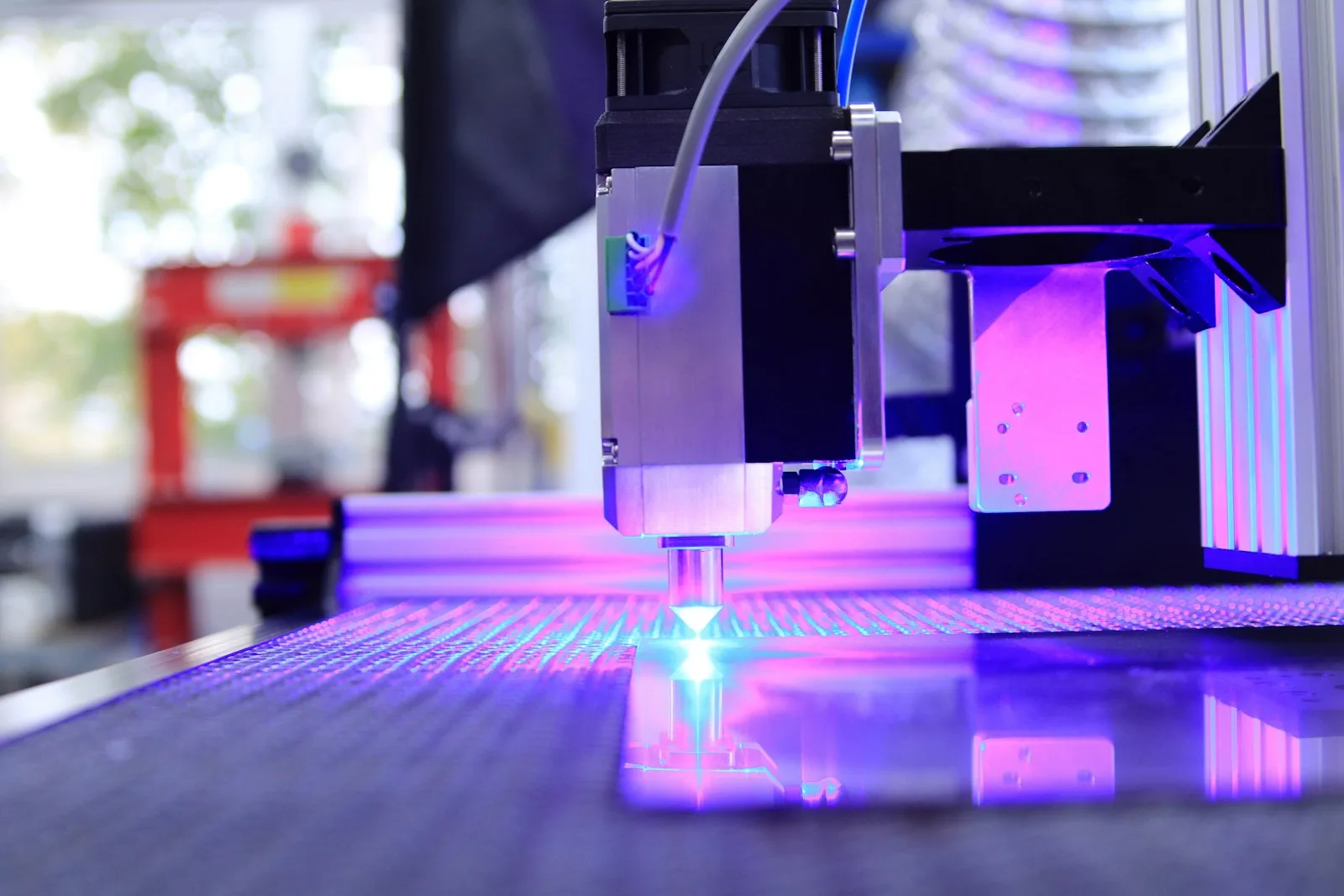 Lasergravur-Kopf mit violettem Licht über dem Arbeitstisch